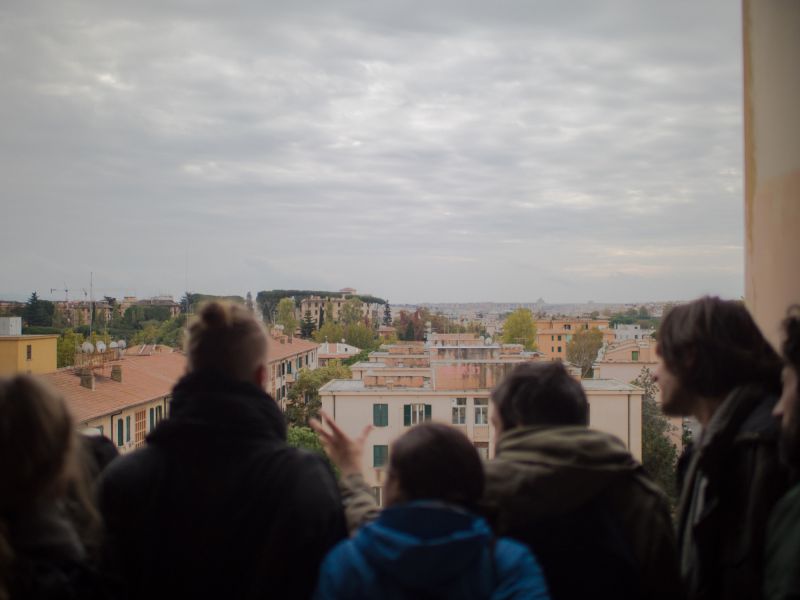 People on roof top, looking over city Rome
